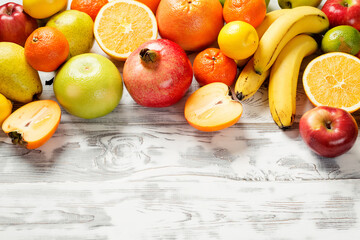 Fresh fruits background. Food photography different fruits on wooden white background.