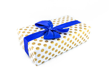 A gift wrapped in white paper with gold circles wrapped in a blue ribbon tied in a bow, isolated on...