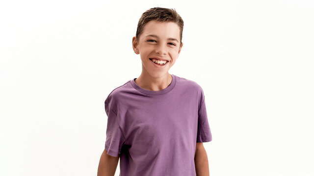 Portrait of happy teenaged disabled boy with cerebral palsy laughing at camera while posing, standing isolated over white background