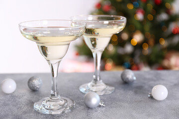 Beautiful christmas composition with two glasses of sparkling wine, decorations on textured table. New year's eve tradition to celebrate with champagne. Close up, copy space, background.
