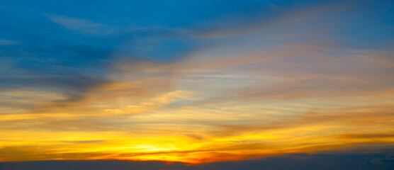 Obraz na płótnie Canvas Beautiful sunset sky above clouds with dramatic light. Wide photo.