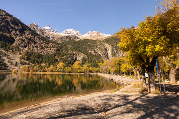 Long exposure of a lake during autumn with snow cap mountain peak in Ordesa Vinamala resort, Spain
