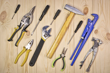 A set of assorted work carpentry and locksmith tools on a light wooden background with copy space.