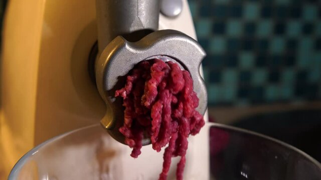Meat minced in the electric meat grinder. Fresh minced meat. Close up. The process of cooking cutlets.