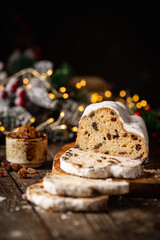 Christmas Stollen. Traditional Sweet Fruit Loaf with Icing Sugar. Xmas holiday table setting.