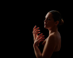 young girl posing in backlight on a black background