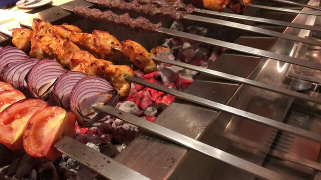 kofta kebabs on charcoal barbecue with smoke.