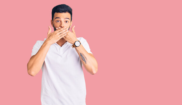 Young handsome hispanic man wearing casual clothes shocked covering mouth with hands for mistake. secret concept.