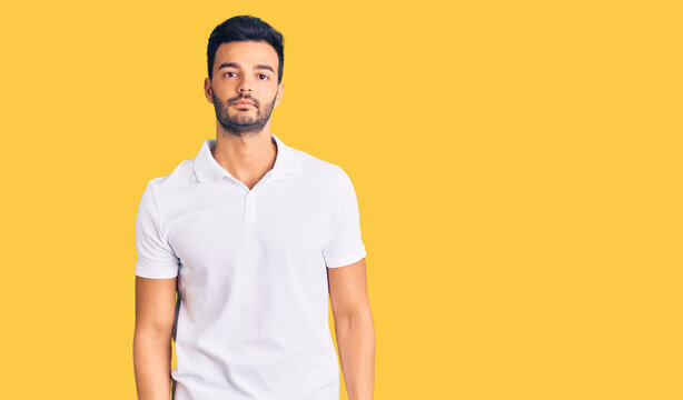Young handsome hispanic man wearing casual clothes relaxed with serious expression on face. simple and natural looking at the camera.