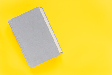 Ultimate gray book on illuminating yellow background. Trend color of the year 2021. Minimalism cocept