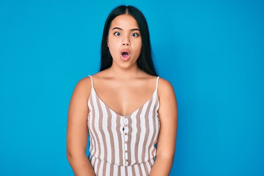 Young beautiful asian girl wearing casual clothes afraid and shocked with surprise expression, fear and excited face.