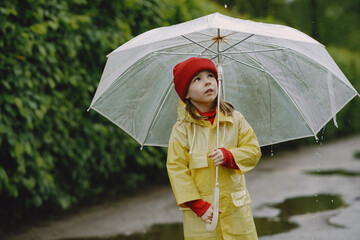 Rainy day. Child having fun outdoors. Kid with umbrella.