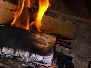 Fireplace with burning firewood. Firewood in the hearth