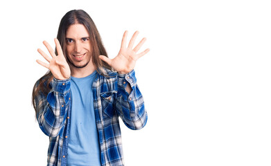Young adult man with long hair wearing casual shirt showing and pointing up with fingers number...