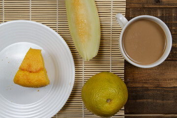 Brazilian breakfast with coffee with milk, corn cake, watermelon and orange fruit