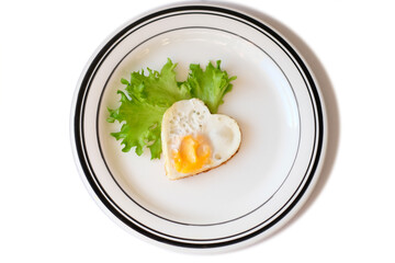 chicken egg on a white plate, shape in the form of a heart, food for a holiday, the concept of a funny surprise for a loved one, valentine's day