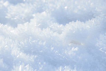 Hoarfrost background texture. Fresh ice and snow winter backdrop with snowflakes and mounds. Seasonal wallpaper. Frozen water geometrical shapes and figures. Cold weather atmospheric precipitation.