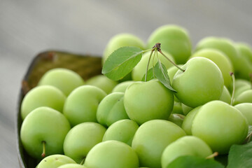 green fresh sour plums and large quantities in the plate,