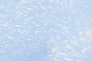 Hoarfrost background texture. Fresh ice and snow winter backdrop with snowflakes and mounds. Seasonal wallpaper. Frozen water geometrical shapes and figures. Cold weather atmospheric precipitation.