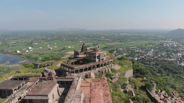 Aerial circling shot of Krishnagiri Fort with beautiful rural indian landscape in background.Cinematic nature footage during sunny day.