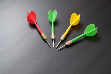 dartboard and red, green and yellow darts on a black background,