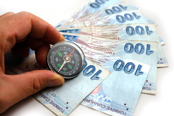compass and 100 turkish lira close-up. to use Turkish lira for economy and investment, correct and accurate investment,
