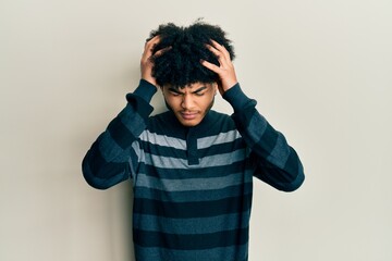 Young african american man with afro hair wearing casual clothes suffering from headache desperate and stressed because pain and migraine. hands on head.