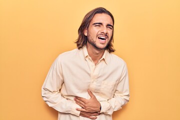 Young handsome man wearing business clothes with hand on stomach because nausea, painful disease feeling unwell. ache concept.