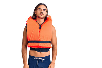 Young handsome man wearing nautical lifejacket relaxed with serious expression on face. simple and...