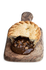Homemade flaky pasty with steak and ale gravy filling isolated on white