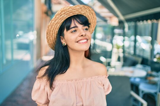 Young hispanic tourist girl wearing summer style walking at the city.