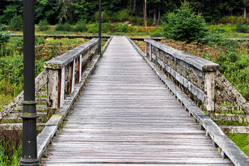 An old grey moss covered boardwalk with rails