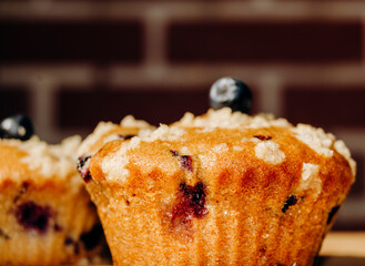 Closeup of a blueberry muffin on brick background. Delicious dessert with berries