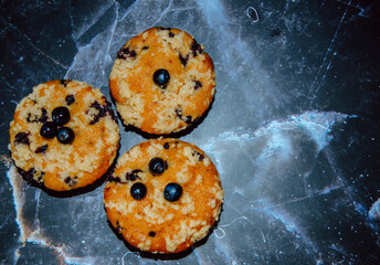 Closeup of a blueberry muffin on black texture. Delicious dessert with berries