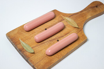 Sausages on a wooden board. Three sausages are lying next to each other. meat product on a white background.