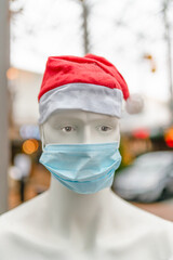 Eine Kunststoff-Schaufensterpuppe mit einer medizinischen Schutzmaske und roter...