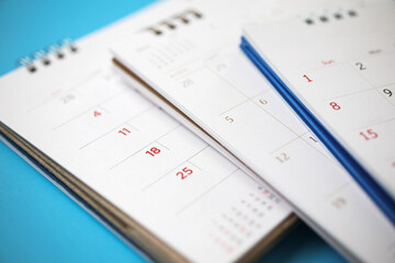 calendar page close up on blue background business planning appointment meeting concept