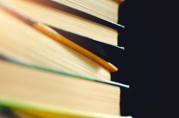 stack of books on a black background. Close-up, selective focus.