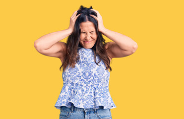 Fototapeta premium Young beautiful brunette woman wearing casual t-shirt suffering from headache desperate and stressed because pain and migraine. hands on head.