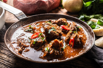 Beef goulash with fresh chillies on a rustic pan