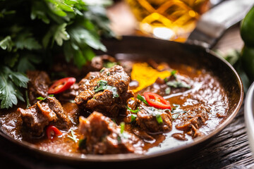 Slow cooked food in a form of a warming beef, veal or pork goulash in a vintage pan