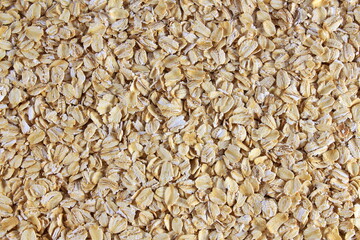 Dry rolled oatmeal flakes as food or health related concept background