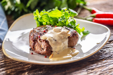 Cooked steak with mushroom sauce and green salad on the side