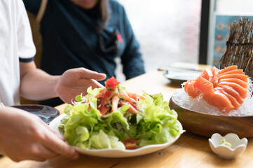 A set of sushi on a wooden table in a Japanese restaurant.Fresh salmon sliced for sushi menu.