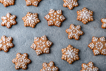 Christmas homemade gingerbread cookies in the shape of snowflakes and herringbone on a blue background. Holiday sweets for decoration and gifts.