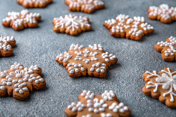 Christmas homemade gingerbread cookies in the shape of snowflakes and herringbone on a blue background. Holiday sweets for decoration and gifts.