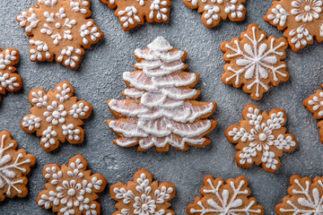 Fototapeta na wymiar Christmas homemade gingerbread cookies in the shape of snowflakes and herringbone on a blue background. Holiday sweets for decoration and gifts.