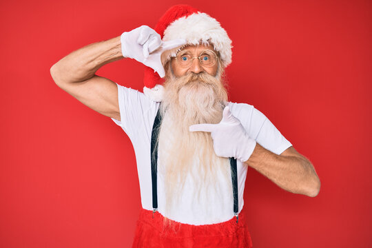 Old senior man with grey hair and long beard wearing white t-shirt and santa claus costume smiling making frame with hands and fingers with happy face. creativity and photography concept.