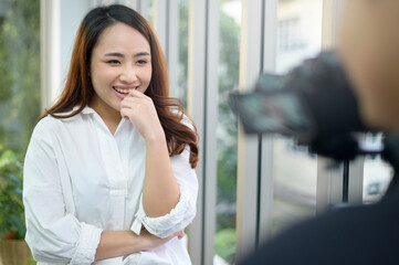 Video camera recording of confident beautiful businesswoman being interviewed, behind the scene concept,