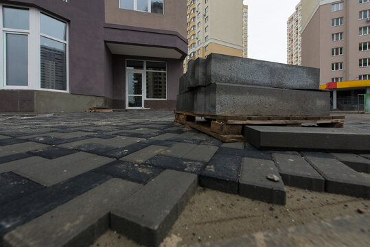 A bricklayer is laying paving slabs. Construction site. production of apartments, social housing.